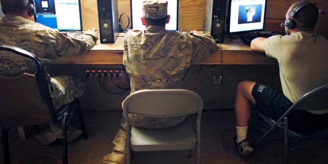 U.S. Army soldiers use computers at Combat Outpost Nolen in the Arghandab Valley north of Kandahar April 14, 2011. (Reuters)