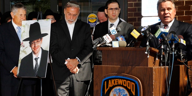 Aug. 26, 2014: U.S. Rep. Chris Smith, right, R-NJ, addresses a gathering as he stands near a photograph of Aaron Sofer, center, 23, in Lakewood, N.J. (AP/Mel Evans)