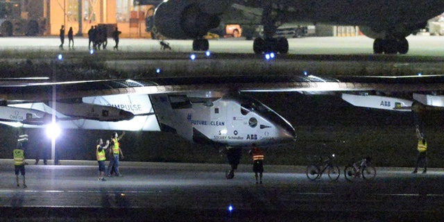 June 1, 2015: The Solar Impulse 2 project staff members gather around the aircraft as it lands the Nagoya Airport in Toyoyama, near Nagoya, central Japan.