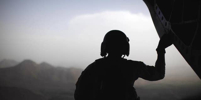 A U.S. Army crewman sits at the rear of a CH-47 Chinook helicopter over eastern Afghanistan, Monday, June 6, 2011. (AP Photo/Jason Reed, Pool)