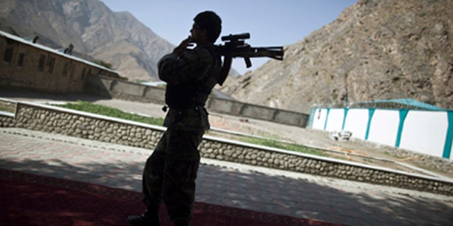 FILE 2011: An Afghan security personnel holds his rifle as he keeps watch during the security handover ceremony in Panjshir province.
