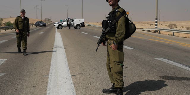 Israeli security forces secure the area after an attack, near the southern Israeli city of Beersheva, Monday, June 18, 2012. Unidentified militants crossed from Egypt's turbulent Sinai Peninsula into southern Israel on Monday, opening light arms and anti-tank fire on civilians building a security fence meant to fortify the porous border, defense officials said. One of the Israeli workers was killed, and two militants were gunned down by troops responding to the attack, the officials said. (AP Photo/Tsafrir Abayov)