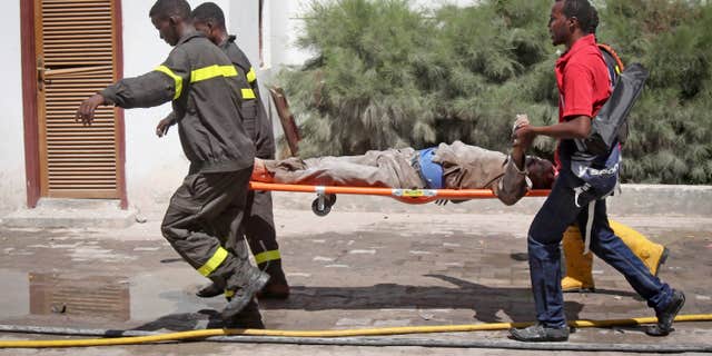 Feb. 20, 2015: Somali rescuers carry away a severely injured civilian from the scene of a twin bombing attack on a hotel in the capital Mogadishu, Somalia.