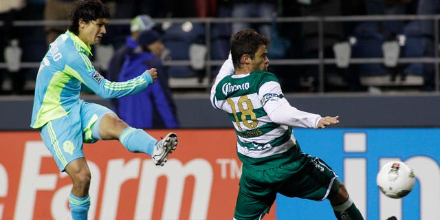 Seattle Sounders FC's Fredy Montero, left, shoots past Santos Laguna's Santiago Hoyos in the second half of a CONCACAF Champions League quarterfinal soccer match, Wednesday, March 7, 2012, in Seattle. The Sounders beat Santos, 2-1.