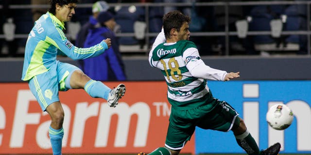 Seattle Sounders FC's Fredy Montero, left, shoots past Santos Laguna's Santiago Hoyos in the second half of a CONCACAF Champions League quarterfinal soccer match, Wednesday, March 7, 2012, in Seattle. The Sounders beat Santos, 2-1.