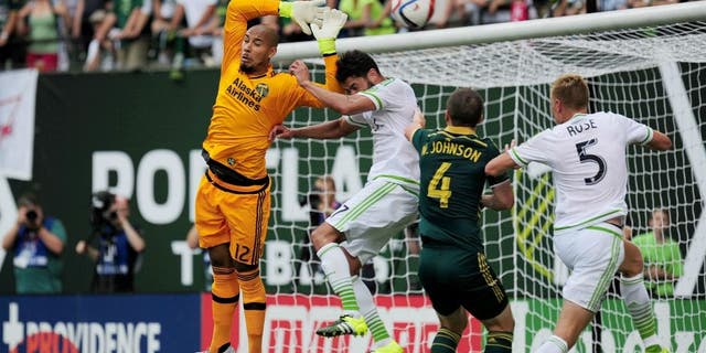 Jun 28, 2015; Portland, OR, USA; Portland Timbers goalkeeper Adam Kwarasey (12) makes sure the ball is out of reach during the first half of the game against the Seattle Sounders at Providence Park. Mandatory Credit: Godofredo Vasquez-USA TODAY Sports