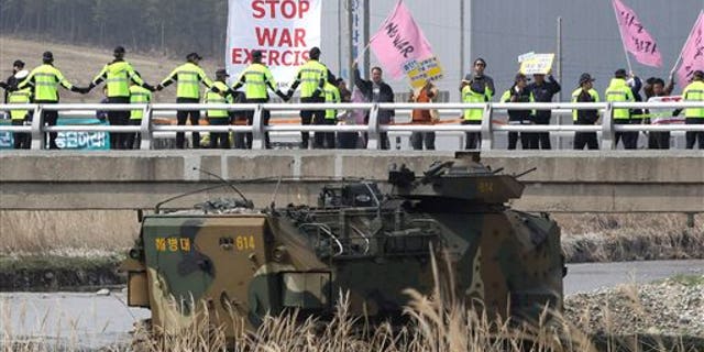Anti-war protesters stage a rally during the U.S.-South Korea joint landing exercises called Ssangyong as part of the Foal Eagle military exercises in Pohang, South Korea, Monday, March 31, 2014. South Korea on Monday returned fire into North Korean waters after shells from a North Korean live-fire drill fell south of the rivals' disputed western sea boundary, a South Korean military official said. (AP Photo/Ahn Young-joon)