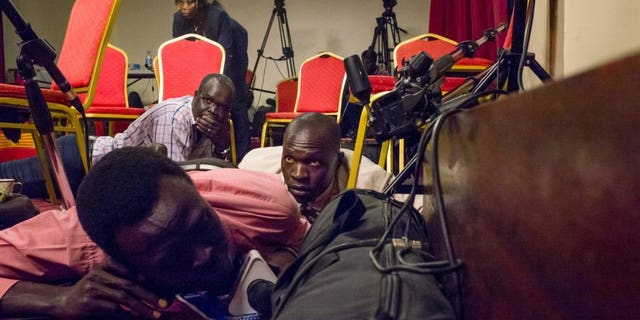 Journalists lie on the floor of a press room in the South Sudan presidential palace after shots were heard on Friday.