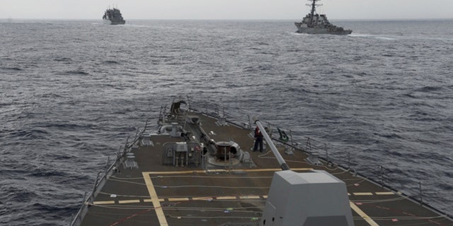 This image provided by the U.S. Navy, taken Oct. 17, 2016, shows the guided missile destroyer USS Decatur, right, pulling into position behind the Military Sealift Command USNS Matthew Perry, during a replenishment-at-sea, seen from the bridge of the guided-missile destroyer USS Spruance, in the South China Sea.