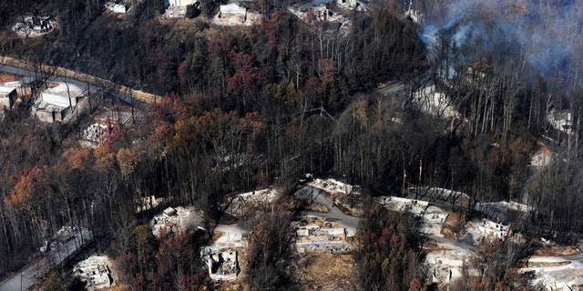 FILE - In this Tuesday, Nov. 29, 2016, file photo, smoke rises from destroyed homes, many burned down to the foundation, the day after a wildfire that hit Gatlinburg, Tenn. Experts said that escaping a fire-filled forest, as thousands did Nov. 28 in the Great Smoky Mountains, can be more traumatic than disasters such as hurricanes, floods or earthquakes. One reason: Flames that scorched neighborhoods in the Gatlinburg, Tenn., area spread so rapidly that people had no time to brace for it. (Paul Efird/Knoxville News Sentinel via AP, File)