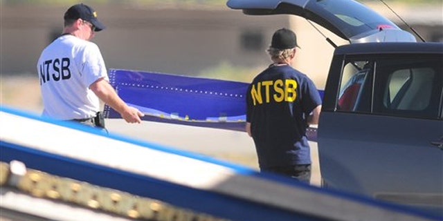 Members of the National Transportation and Safety Board investigating the emergency landing of Southwest Airlines flight 812, carry a portion of the planes fuselage to a waiting vehicle on April 3 in Yuma, Ariz.