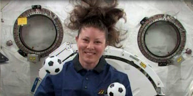 NASA astronaut Tracy Caldwell Dyson plays with mini soccer balls in the weightless environment of the International Space Station. She and her crewmates plan to cheer on the games at the 2010 World Cup international soccer tournament.