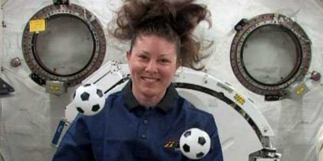NASA astronaut Tracy Caldwell Dyson plays with mini soccer balls in the weightless environment of the International Space Station. She and her crewmates plan to cheer on the games at the 2010 World Cup international soccer tournament.