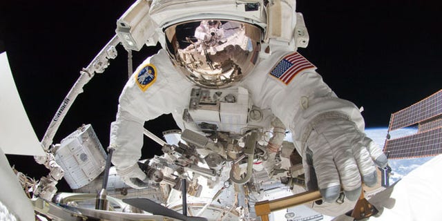 NASA astronaut Greg Chamitoff takes center stage in this amazing spacewalk photo taken by crewmate Mike Fincke (visible in the reflection on Chamitoff's spacesuit visor) using a fish-eye lens and digital camera during a May 27, 2011 excursion outside the International Space Station.