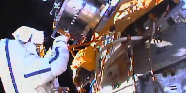This photo taken from video provided by NASA shows Russian cosmonauts Yuri Malenchenko and Sergey Volkov install fresh experiments outside the International Space Station on Wednesday, Feb. 3, 2016. The spacewalkers set off to retrieve biological samples that have been outdoors seven years, and put out some new science trays. They also planned to test a new glue that might prove useful in years to come on the station's exterior. (NASA via AP)