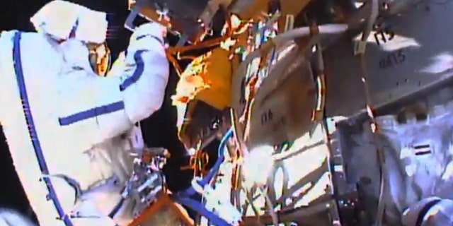This photo taken from video provided by NASA shows Russian cosmonauts Yuri Malenchenko and Sergey Volkov install fresh experiments outside the International Space Station on Wednesday, Feb. 3, 2016. The spacewalkers set off to retrieve biological samples that have been outdoors seven years, and put out some new science trays. They also planned to test a new glue that might prove useful in years to come on the station's exterior. (NASA via AP)
