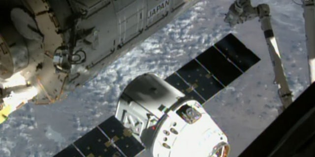 SpaceX’s uncrewed Dragon cargo ship approaches the International Space Station (ISS) on April 17, 2015, in this still from a camera on the orbiting lab’s exterior. This same Dragon arrived at the space station on Dec. 17, 2017.
