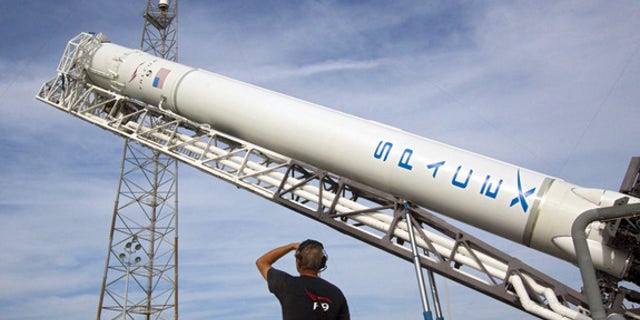 At Space Launch Complex 40 on Cape Canaveral Air Force Station in Florida, the Space Exploration Technologies, or SpaceX, Falcon 9 rocket is moved into a vertical position for a wet dress rehearsal. This image was released Aug. 31, 2012.