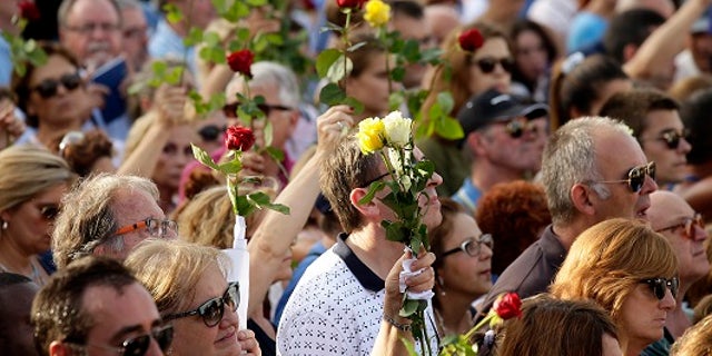 People in Barcelona held flowers during a demonstration condemning last week's terror attacks that killed at least 15 people.