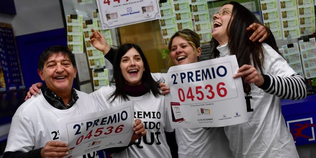 Agustin Moreno, owner of a lottery office, left, celebrates with Ainoha, Maribi and Monica, after selling the second prize Christmas lottery ticket ''El Gordo'' with the number 04536, in Pamplona, northern Spain, Thursday, Dec. 22, 2016. Celebrations were guaranteed Thursday in Madrid where tickets bearing the top prize number of 66513 in Spain's Christmas lottery, "El Gordo" were sold. (AP Photo/Alvaro Barrientos)