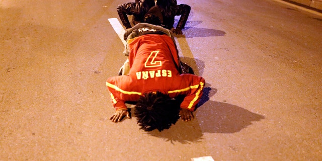 Migrants pray on a street after storming a fence to enter the Spanish enclave of Ceuta, Spain, Friday, Feb. 17, 2017.