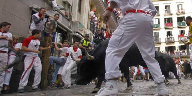 July 7, 2012: Revelers run on the Estafeta corner ahead of Dolores Aguirre Yabarra ranch bulls during the first running of the bulls at the San Fermin fiestas, in Pamplona northern Spain