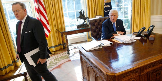 White House Communications Director and spokesman Sean Spicer (L) stands with U.S. President Donald Trump at the conclusion of an interview with Reuters in the Oval Office at the White House in Washington, U.S. February 23, 2017. REUTERS/Jonathan Ernst - RTS101X8
