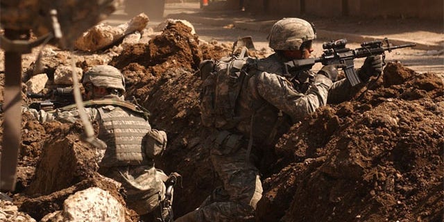 Soldiers occasionally get a sixth sense feeling about battlefield dangers. Here, Sgt. Auralie Suarez and Pvt. Brett Mansink take cover during a firefight with anti-Iraqi forces in the Al Doura section of Baghdad, March 7.