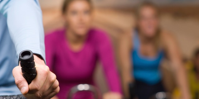 Women Working Out on Exercise Bicycles at Gym
