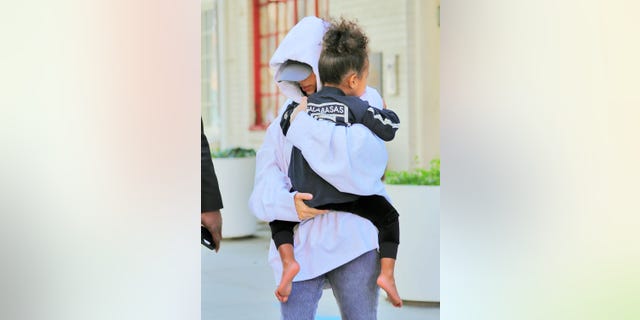 Kim Kardashian runs to her waiting SUV with North West in New York.