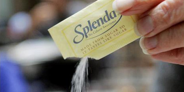 An unidentifed woman pours Splenda into a cup in a coffee shop in Boston Friday, Dec. 3, 2004. Dieters hoping for a slew of new products with the sugar substitute Splenda may be disappointed next year. That's because the maker of sucralose, the key ingredient behind the increasingly ubiquitous no-calorie sweetener, is having trouble keeping up with demand. (AP Photo/Winslow Townson)