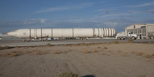 Mounted on special lowboy trailer dollies, one of the two space shuttle solid rocket boosters is hauled up the ramp from Rogers Dry Lake after arrival at NASA’s Dryden Research Center in California.