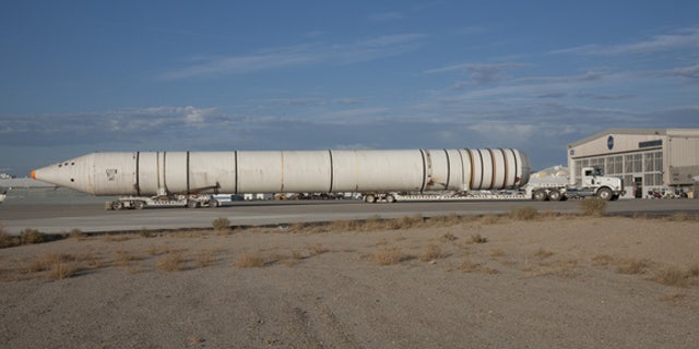Mounted on special lowboy trailer dollies, one of the two space shuttle solid rocket boosters is hauled up the ramp from Rogers Dry Lake after arrival at NASA’s Dryden Research Center in California.