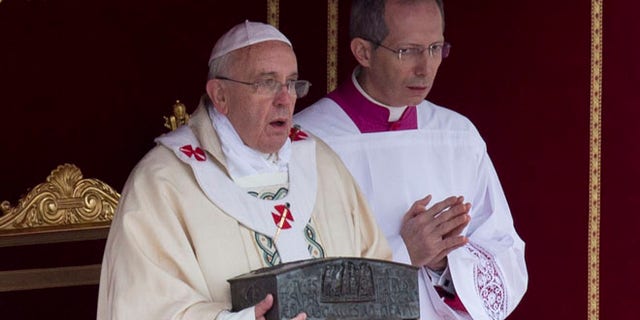Nov. 24, 2013: Pope Francis, left, holds the relics of St. Peter as he celebrates mass for the end of the Year of Faith, in St. Peter's Square at the Vatican.