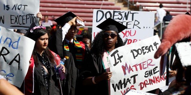 Protesters demonstrate during Stanford University graduation exercises at Stanford Stadium, Sunday, June 12, 2016, in Stanford, Calif. A group of women's rights advocates are urging a California agency to take action against the judge who sentenced a former Stanford University swimmer to six months in jail for sexually assaulting an unconscious woman. (AP Photo/D. Ross Cameron)
