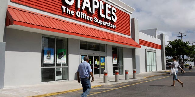 This March 6, 2013 file photo shows a Staples office supply store Miami. The opening of Postal Service retail centers in dozens of Staples stores around the country is being met with threats of protests and boycotts by the agencys unions. The new outlets are staffed by Staples employees, not postal workers, and labor officials say that move replaces good-paying union jobs with low-wage, nonunion workers.