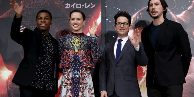 December 11, 2015. Director J.J. Abrams (2nd R), cast members John Boyega (L), Daisy Ridley (2nd L), and Adam Driver pose for pictures with "Star Wars" character BB-8 8(C) in Tokyo.