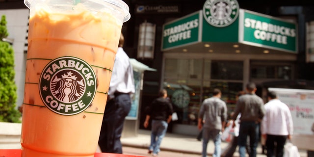 A Starbucks drink is seen on a table in New York's Times Square April 21, 2010. Shares in coffee chain Starbucks, which is due to report results later in the day, fell 0.6 percent. McDonald's encroached further into Starbucks Corp territory this quarter by introducing lower-priced frappes designed to compete with Frappuccinos. REUTERS/Shannon Stapleton (UNITED STATES - Tags: BUSINESS) - RTR2D3CV