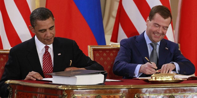 FILE: In this April 8, 2010, photo, President Obama signs the New START treaty with Russian President Dmitry Medvedev at the Prague Castle.