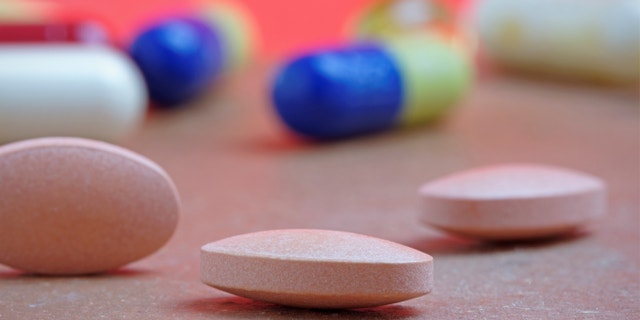 Close up of statin tablet or generic pill with out of focus tablets in background