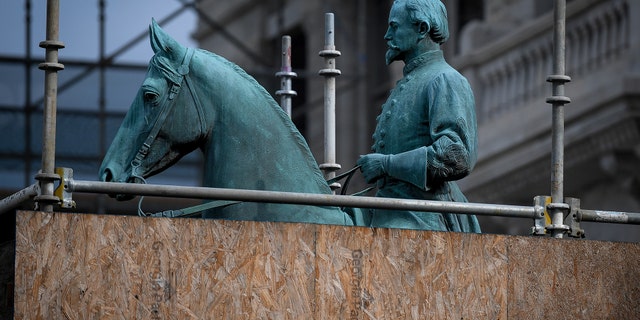 A monument to Confederate General John Hunt Morgan stands encased in a protective scaffolding because of local construction, outside the Historic Lexington Courthouse in Lexington, Ky.