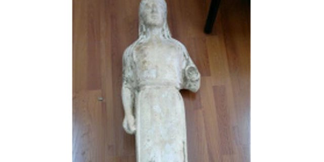 March 28, 2012: A 2,500-year-old statue of a young woman that was illegally excavated and hidden in a goat-pen near Athens is seen in this police handout photo.