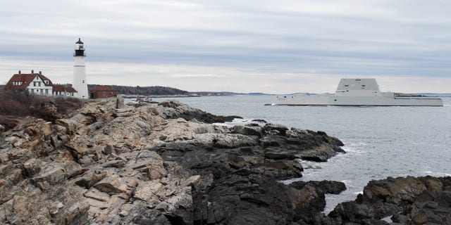 The USS Zumwalt passes Portland Headlight in Cape Elizabeth, Maine.