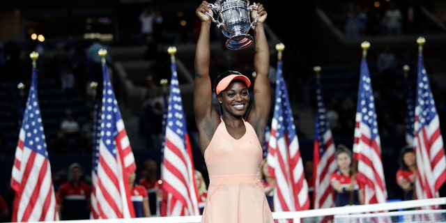 Sloane Stephens, of the United States, holds up the championship trophy after beating Madison Keys, of the United States, in the women's singles final of the U.S. Open tennis tournament, Saturday, Sept. 9, 2017, in New York. (AP Photo/Julio Cortez)