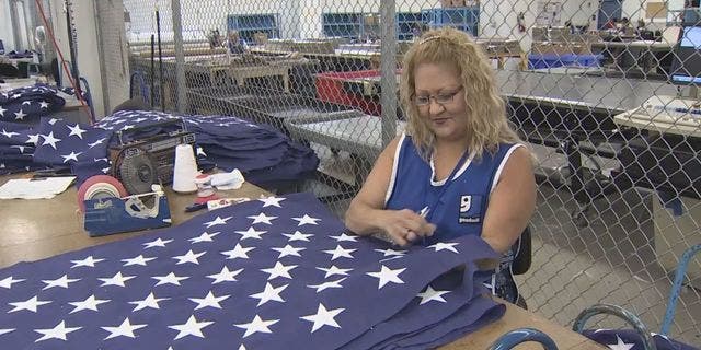 Goodwill employee works on flag at Goodwill Flag Center in South Florida. (WSVN)