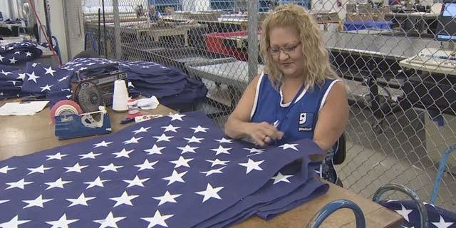 Goodwill employee works on flag at Goodwill Flag Center in South Florida. (WSVN)
