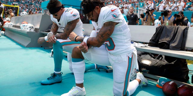 Miami Dolphins receivers Kenny Stills, left, and Albert Wilson kneel during the playing of the national anthem prior to their game against the Tennessee Titans Sunday.