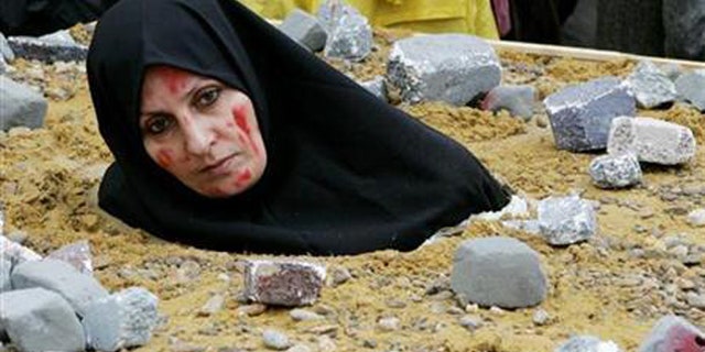 For this photo, an Iranian woman symbolically dressed up as a victim of death by stoning as part on a protest by the National Council of Resistance of Iran in Brussels. (Reuters)