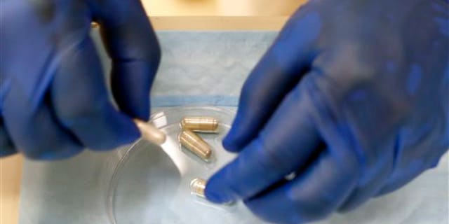 Dr. Thomas Louie, an infectious disease specialist at the University of Calgary, prepares stool pills in his lab in Calgary, Alberta, Canada on Thursday, Sept. 26, 2013.