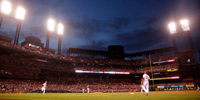 St. Louis Cardinals' Stephen Piscotty heads to first on a single as dusk falls over Busch Stadium during the fourth inning of a baseball game against the Milwaukee Brewers Tuesday, May 2, 2017, in St. Louis. (AP Photo/Jeff Roberson)